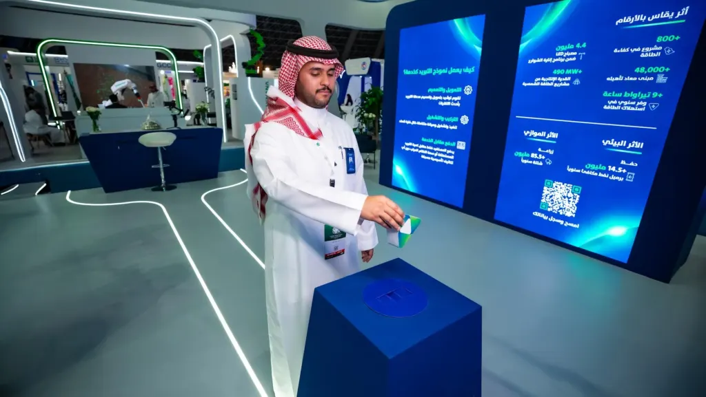 Visitor using the interactive pedestal in front of Tarshid information screens