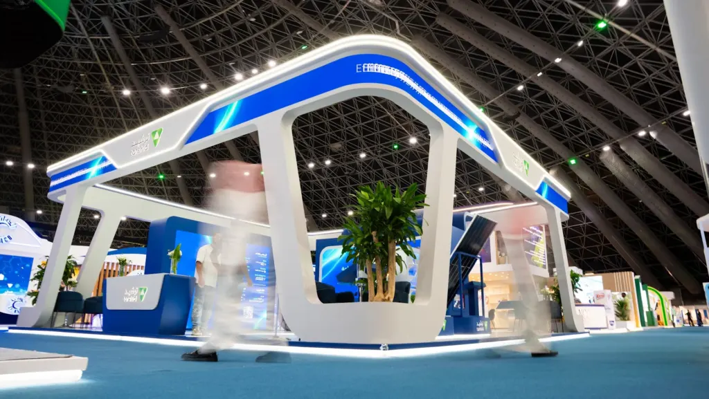 Corner view of the 120 sqm Tarshid stand with white curved arches and blue LED edge lighting